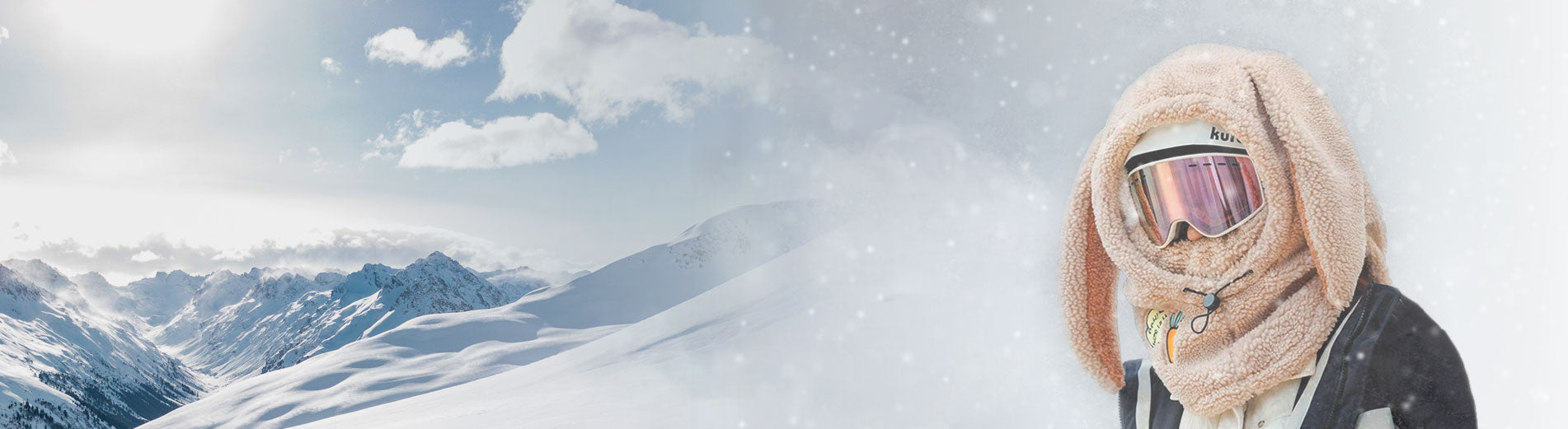 Snow-covered mountain range with a skier wearing a plush Plushy Warmy helmet hood